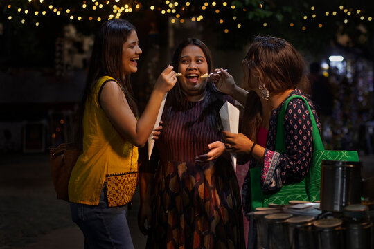 Women eating Jhalmuri at roadside stall