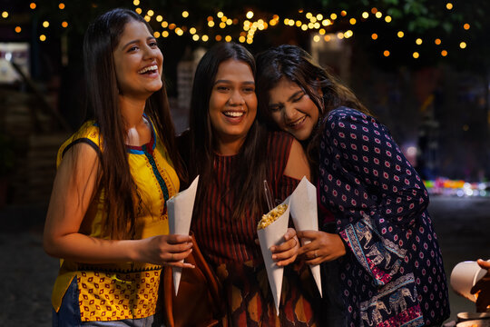 women having fun and eating Jhalmuri on street