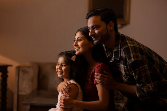 Happy young couple spending good time together with their daughter at home