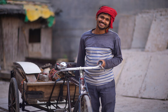 Portrait of a rickshaw puller with his rickshaw and his workload 