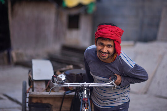 Portrait of a rickshaw puller with his rickshaw and his workload 