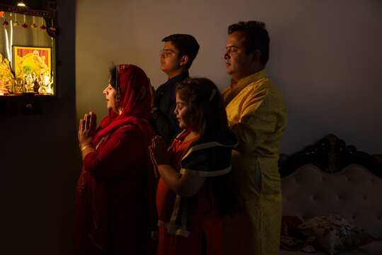 Portrait of family praying to God together at home