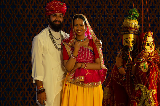 Portrait of a Rajasthani couple with puppets in the foreground. 