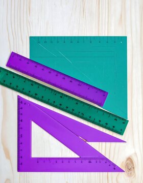Colorful Plastic Drafting and Geometry Rulers on a Wooden Background.