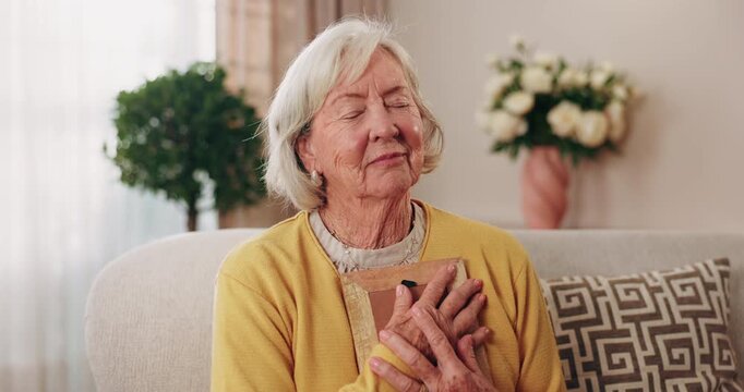 Memory, photo and senior woman on sofa with nostalgia, remember and sad for loss, grief and lonely. Retirement, widow and elderly person with photograph hug, frame and thinking with reminder in home
