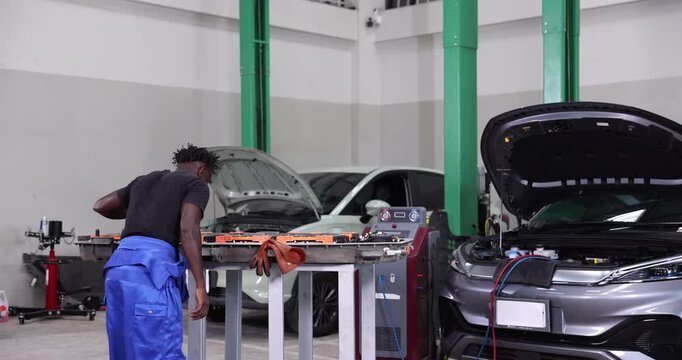 Professional EV technician shaking hands with a customer after successfully completing high-voltage battery maintenance in a modern electric vehicle service center.