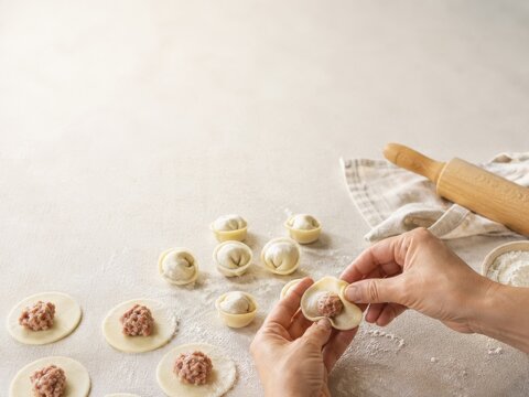 Preparaci&oacute;n de empanadillas en una cocina con masa fresca y relleno de carne