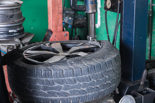 Pneumatic tire changer machine utilizing a mount head to install a rubber tire onto an alloy wheel rim. Automated mechanic equipment for wheel service in an auto repair garage