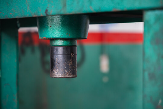 Close up of a heavy-duty hydraulic press piston in an auto repair shop. Industrial metalworking machinery and mechanical equipment for vehicle maintenance and bearing extraction
