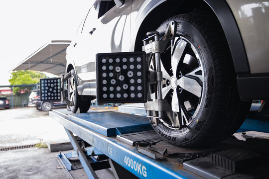 Wheel alignment sensor target attached to a car tire. Professional auto repair garage service for vehicle steering calibration and safety maintenance