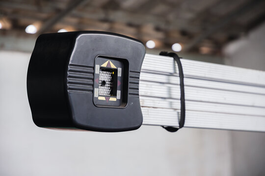 Precision 3D wheel alignment camera sensor mounted on an aluminum beam. Modern diagnostic technology and calibration equipment in a professional auto repair garage