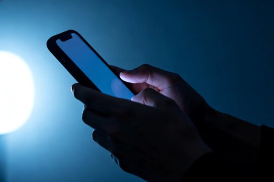 Hands Using Smartphone in Dim Light