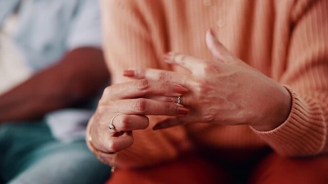 Couple, hands and woman with ring for regret, marriage mistake and doubt in relationship in home. Man, wife and fidget with jewelry for commitment crisis, separation anxiety and divorce with partner