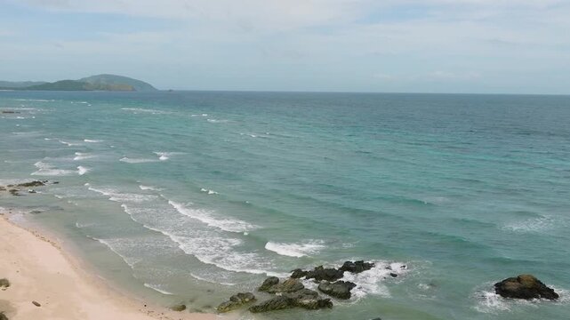 Ocean waves on white sand and rocks. Santa Fe, Tablas, Romblon. Philippines.