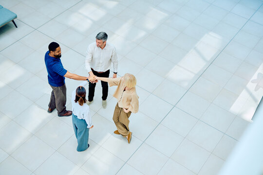 Business people forming a stack of hands, symbolizing teamwork, partnership, and agreement towards a common goal