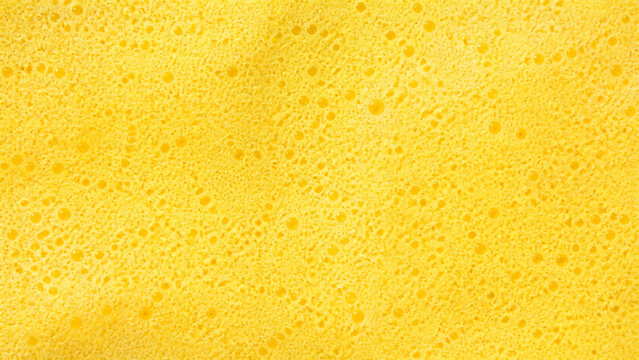 Micro bubble foam surface in butter yellow abstract texture background