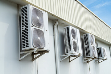 Fototapeta premium Air conditioner air compressor cold electric fan cooling temperature external on wall cement building outdoor construction, electric fan power supply technology