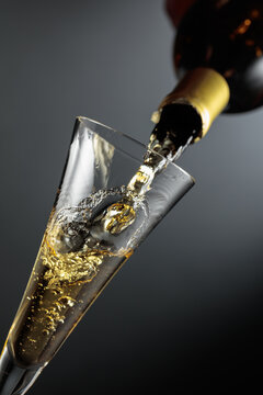 White sparkling wine is poured from a bottle into a glass.