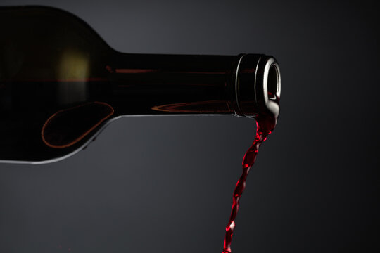 Red wine pours out of the bottle.