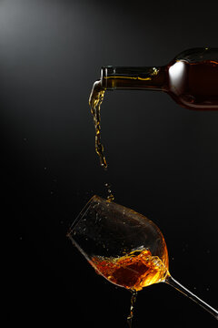 White wine of rich amber color being poured into a glass.