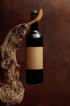 Bottle of red wine with empty label on a old wooden snag.