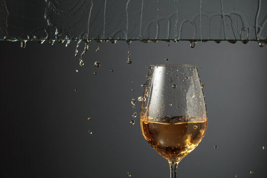 White wine flows down into a glass.