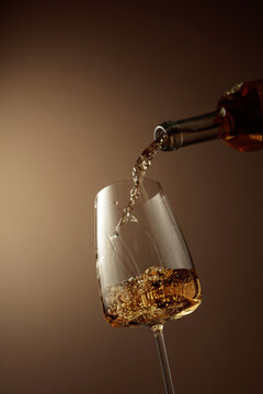 Pouring white wine from a bottle into a glass.