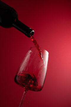 Pouring red wine from a bottle into a glass.