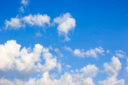 Bright Blue Sky with Fluffy White Clouds Background