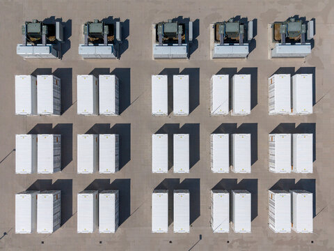 Aerial view of the Olsterdwarspad battery energy storage system with rows of white containers and wind turbines, Dronten, Flevoland, The Netherlands