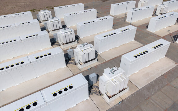 Aerial view of the Olsterdwarspad battery energy storage system with rows of white containers and wind turbines, Dronten, Flevoland, The Netherlands