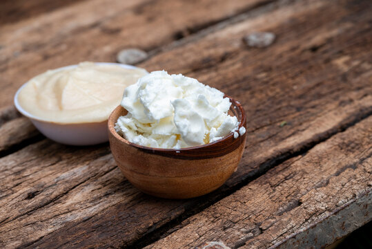 Ghee or clarified butter in wooden bowl, cooking oil, pure ghee on wooden background