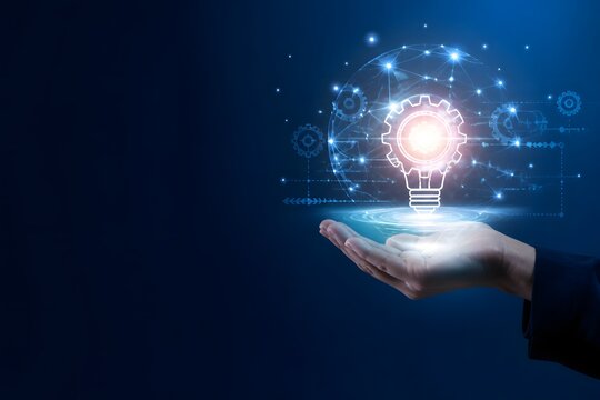 A hand holding a glowing light bulb gear icon representing creative business innovation and digital transformation strategy in a modern blue tech environment with ample copy space for marketing