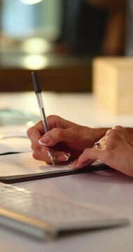 Writing, hands and woman with notebook in office for reminder, planning and schedule for project. Night, creative and person with to do list for tasks, productivity and agenda for business proposal