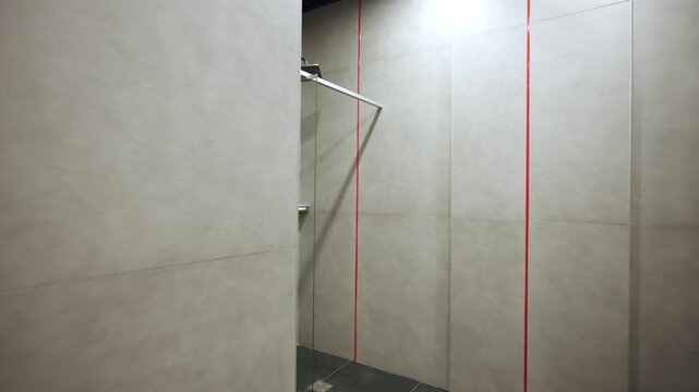 Contemporary bathroom interior features minimalist stalls with compact soap holders. Clean orderly space looks ready for athlete hygiene