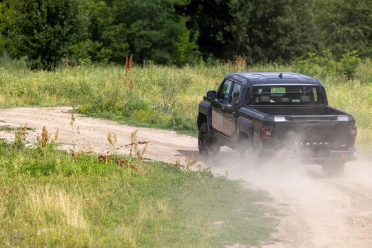 A black Kia Tasman all-wheel drive pickup truck kicks up dust during a test drive on a dirt road in Lisnyky, Kyiv Region, Ukraine Detailed visual documentation of the current events and surroundings