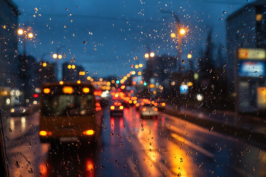 Rainy Evening City Street with Traffic and Streetlights.