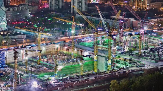 Asia, China, Beijing, zoom out time lapse of busy construction site at night in Beijing's central financial district Soho, with tower blocks and the CCTV tower