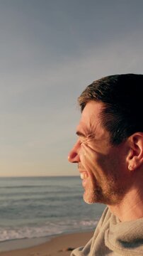 Emotional middle-aged man standing on a serene beach at sunset, shedding tears of happiness and relief while looking at the peaceful ocean, finding hope and new beginnings in a moment of catharsis