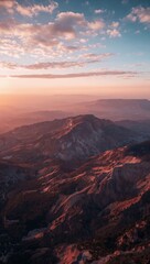 Naklejka premium Breathtaking aerial view of mountain peaks during a vibrant golden hour sunset.