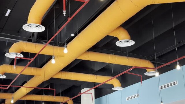 Modern industrial ceiling design with yellow HVAC ventilation ducts