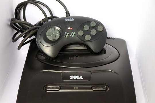 Salvador, Brazil - July 11, 2026: Sega Mega Drive III video game with joystick on white background. Mega Drive 3. Vintage video game. 