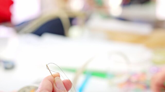 Hand threading a needle for sewing
