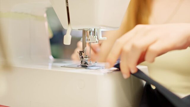 Seamstress using a sewing machine in a workshop