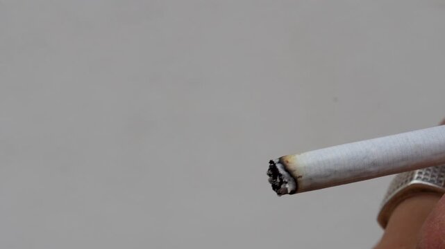 Close up of male hand lighting a cigarette with a lighter