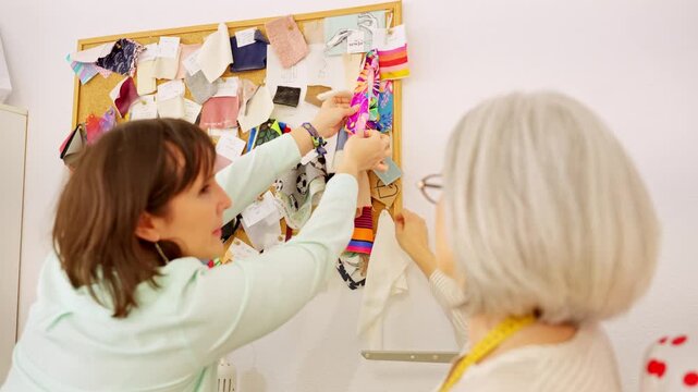 Two fashion designers brainstorming with fabric swatches