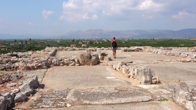 Woman walking through the Tiryns archaeological ruins in Greece