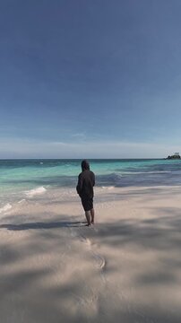 Person Standing Towards Ocean on Sandy Beach