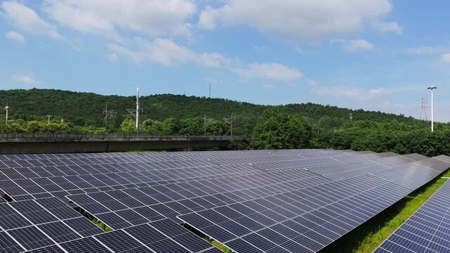 Aerial view of solar power plant with forested hills beyond