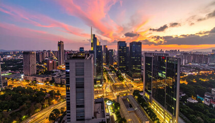 Fototapeta premium Expansive urban cityscape at dusk showcasing a vibrant sunset over illuminated buildings and glowing traffic lights.